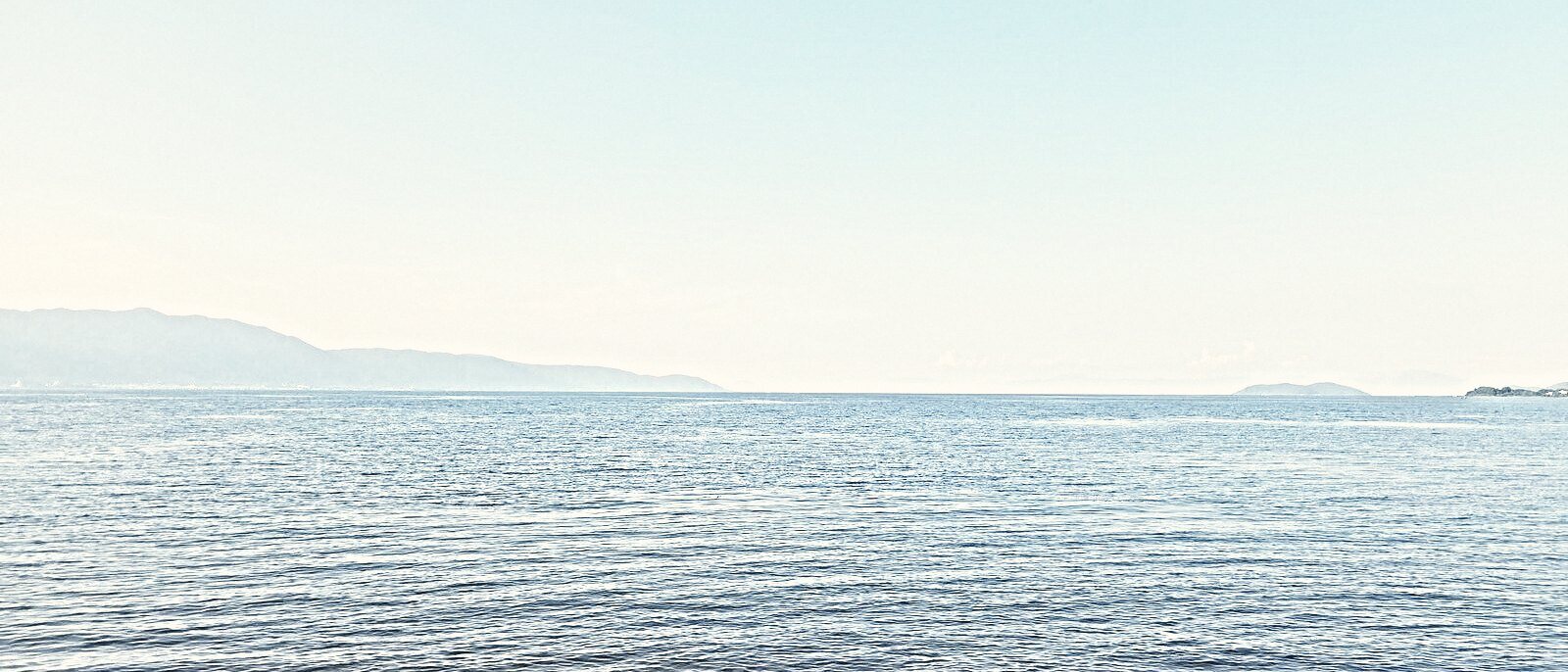 A wide calm band of Lake Biwa, the far shore a pale line across the water.