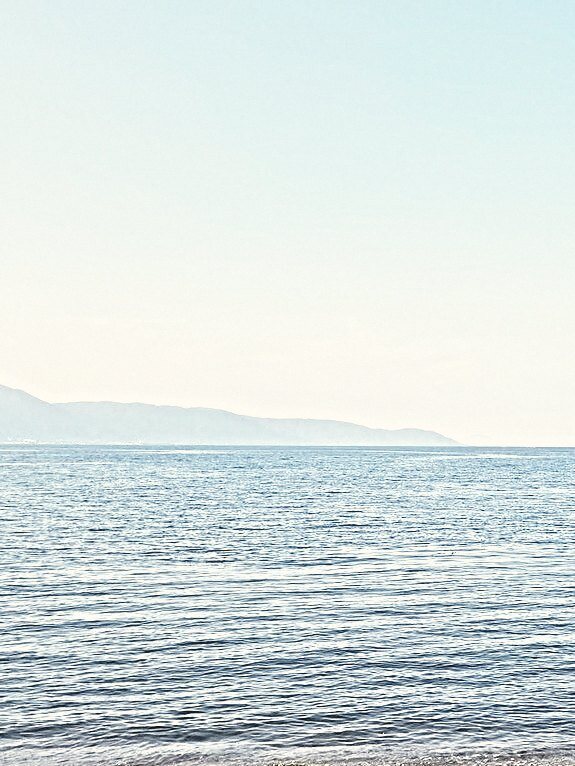 Lake Biwa in flat morning light, far mountains along the horizon.