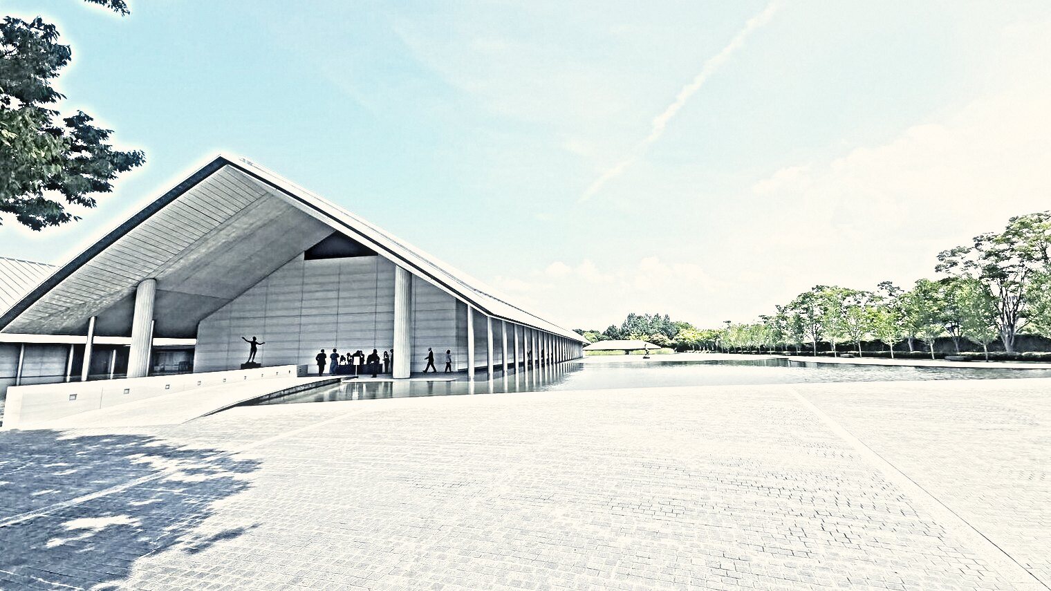 A long low pavilion with a wide eaved roof standing over still water, trees along the far bank.